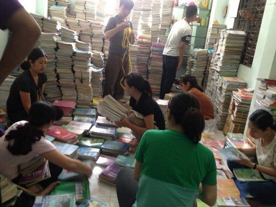 年輕人正在把剛收到的書籍分類，然後疊成一疊疊的。