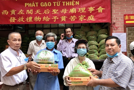 林和會長(左)與雙成隆安有限公司丁文森(右)向窮人贈送禮物。