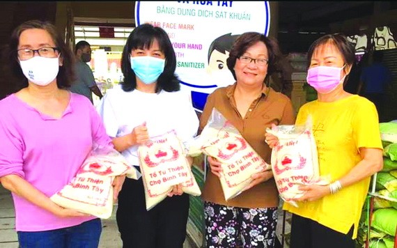 華人商販應氏蓮（右一）與各商販在準備向貧困者派發大米。