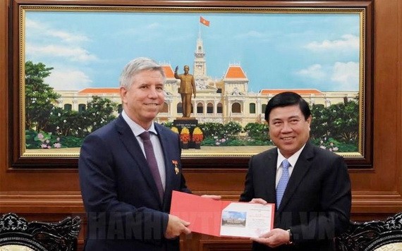 市人委會主席阮成鋒（右）向英國駐本市總領事伊恩‧比本斯贈送紀念品。（圖源：市黨部新聞網）