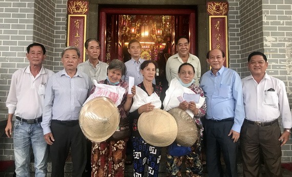 鄭鑫發(左二)、曾業文(右二)與值理會成員向窮人贈送禮物。