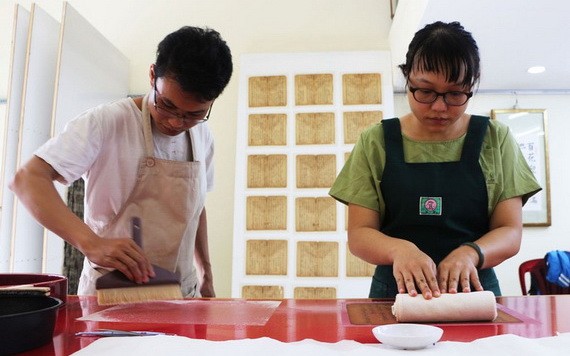 裴進福與佩泉正在複製漢喃書籍。