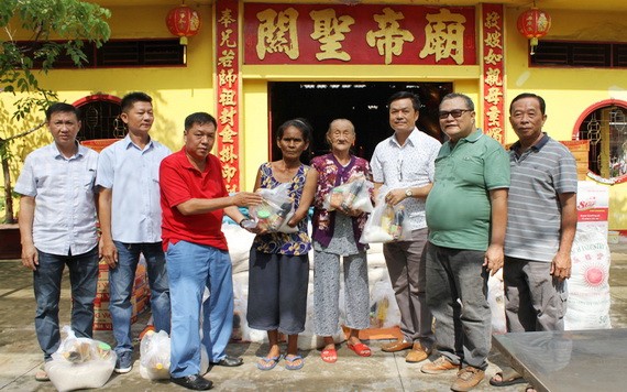 決勝村關帝廟理事長楊振明(左三)、副理事長兼財政陳昶霖(右三)與諸位理事 向貧困者派發賑濟品。