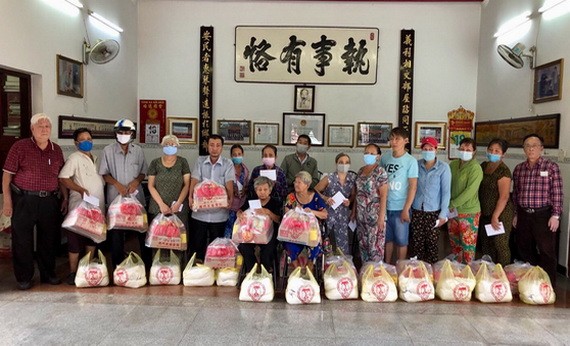 義安會館理事長陳裕(左一)向鄉親派發賑濟品。