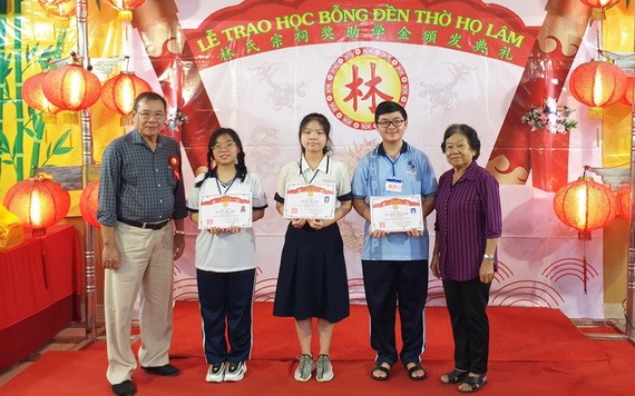 郡勵學會主席李金梅(右一)、常值副會長林晉章(左一)向３名市級優秀生頒發獎學金。