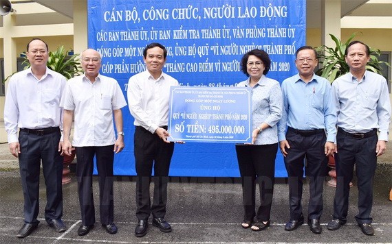 市越南祖國陣線委員會主席蘇氏碧珠（右三）象徵性接領由市委常務副書記陳留光（左三）移交的“為窮人”基金活動經費。（圖源：市黨部新聞網）