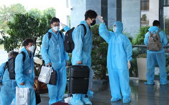 外國專家們進入自費隔離酒店前測量體溫。