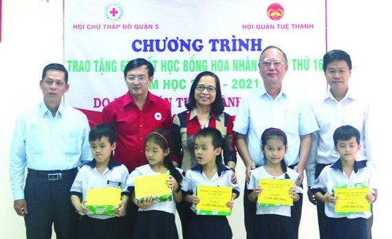 盧耀南理事長(右二)與本市、第五郡領導向五胞胎兄弟姐妹頒發獎學金。