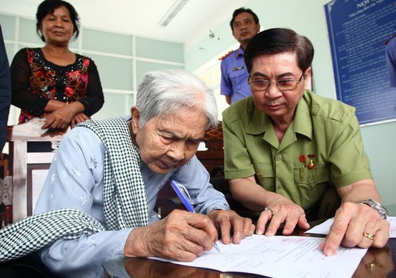 武氏商老大娘簽領冤案精神損害賠償金。（圖源：江芳）