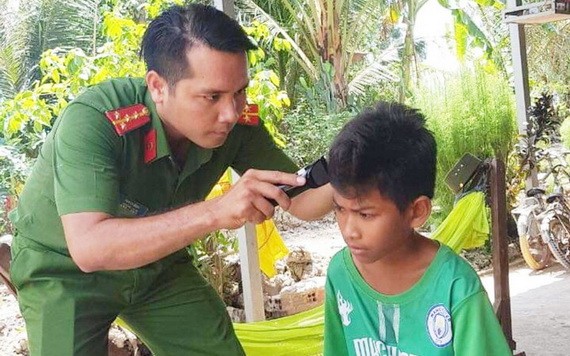 石平大尉正為小朋友理髮。