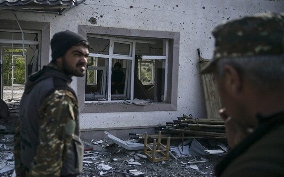 圖為亞美尼亞士兵站在被部分摧毀的軍事醫院建筑前。（圖源：AFP）