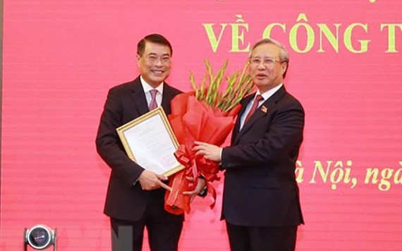 新任黨中央辦公廳主任黎明興（左）從黨中央書記處常務書記陳國旺手中接過人事委任《決定》。（圖源：越通社）