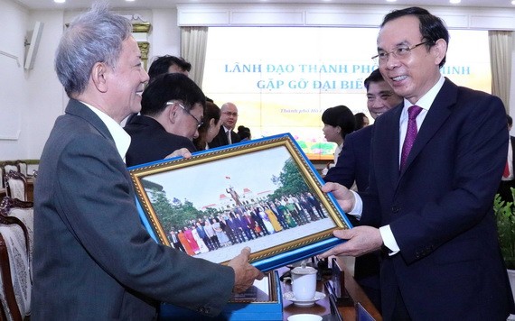 黨中央書記、市委書記阮文年（右）向僑胞贈送紀念品。