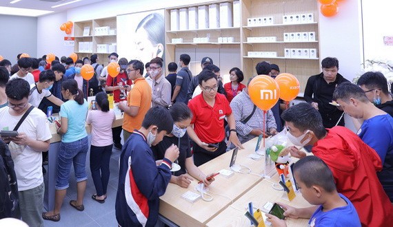 新張小米授權店吸引眾多年輕消費者前來體驗、購置各款新型智能手機。