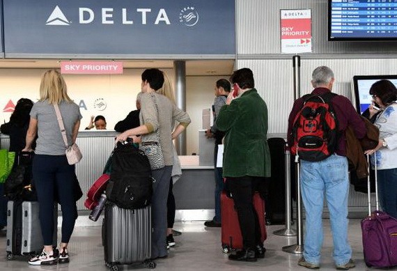 乘客在達美航空櫃檯辦理登機手續。（圖源：Getty Images）