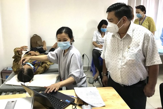 丁文森觀察醫生給病人在施手術前檢查眼睛。