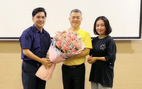 中文系副主任阮福祿送花給大發餅家總經理許玉林（中）。