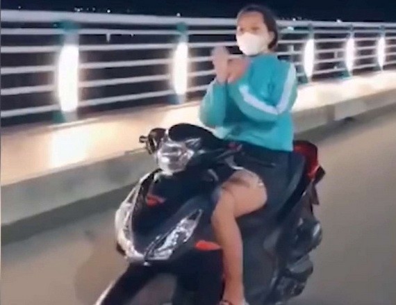 女騎士不但放手騎車，還在高速中揮舞雙手模仿扇子舞姿態，模樣相當危險。（圖源：視頻截圖） 
