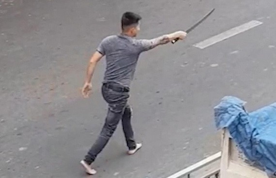 一名男子手持長劍在馬路上氣洶洶尋找對方“算賬”。(圖源:視頻截圖)