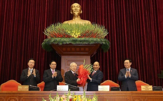 政府總理阮春福代表黨中央政治局向蟬聯黨中央總書記阮富仲同志送上鮮花。（圖源：越通社）