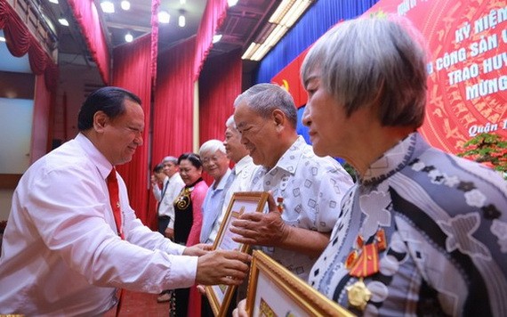 第十一郡郡委副書記陳飛龍（左）向各位高齡黨員頒授黨齡紀念章。（圖源：愛真）