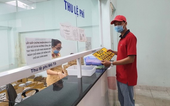 一名司機在市公安廳陸路與鐵路交通警察科辦事處換取黑子黃色車牌。（圖源：詩絨）