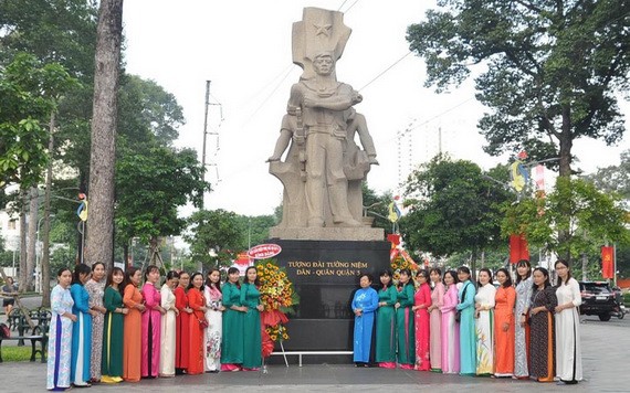 民族婦女工作組的成員穿長衫在第五郡民軍紀念台前合影。