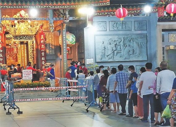 新冠肺炎疫情影響下，善信們排隊進廟內上香祈福。