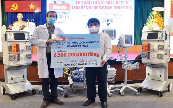 《年輕人報》總編輯黎世渚（右）象徵性向市熱帶病醫院院長阮文永洲醫生（左）移交總值65億元的防疫醫療設備。（圖源：緣潘）