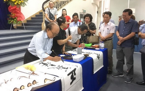 人民藝人張路書畫家（左一）現場揮毫書法。