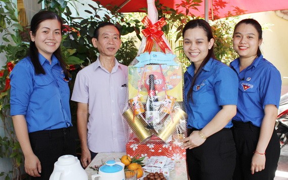 共青團第五郡郡委代表團向華人老幹部梁鴻德(左二)贈送禮物。