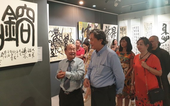 人民藝人張路書畫家(左一)向來賓介紹書法作品。