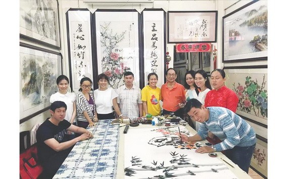 張漢明老師（右起第五位）讓學生實習畫作。