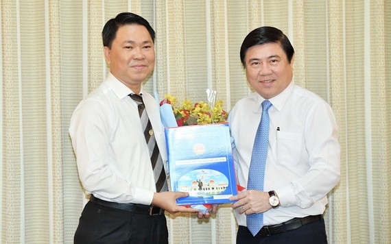 新任市建設廳長陳黃軍（左）從市人委會主席阮成鋒手中接過人事委任《決定》。（圖源：越勇）