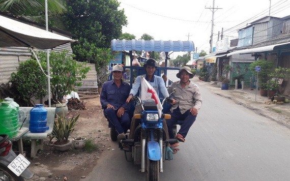 陳文懷（右）與三輪車隊成員們在去砍柴的途中。