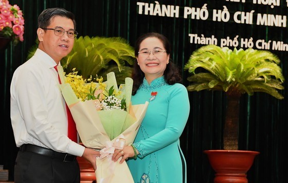 市人民議會主席阮氏麗（右）向阮文勇同志（左）贈送鮮花表示祝賀。