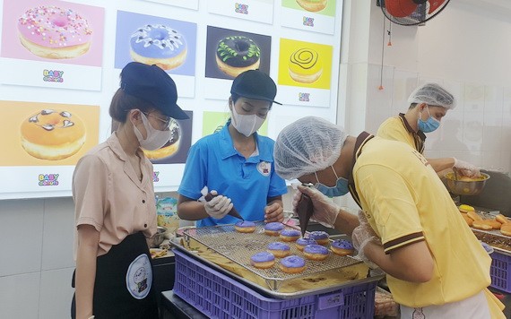 烘焙師按消費者要求製做甜甜圈。