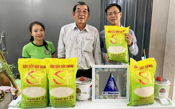 ST25大米品牌研發人胡光郭（中）與推銷員在推介ST25大米品牌。（圖源：H.Đ）