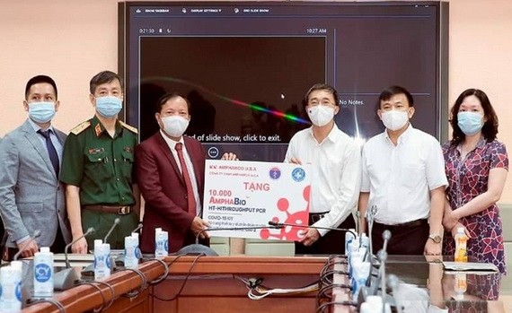 衛生部副部長陳文舜（右三）象徵性接領由美國Ampharco藥品股份公司贈送的1萬新冠病毒檢測試劑盒。（圖源：陳姮）