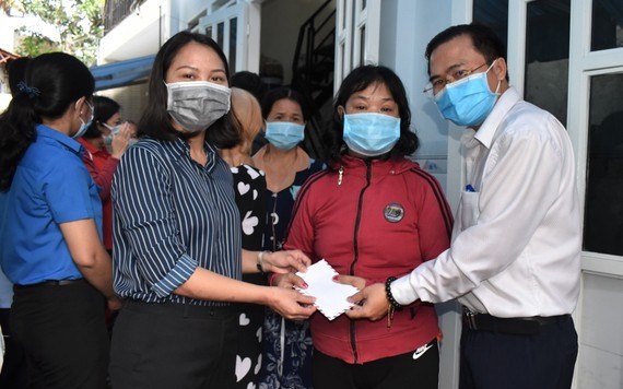 市人民議會辦公廳主任高清平（右一）慰問守德市遭嚴重水淹的民戶並贈送禮物。（圖源：廷理）