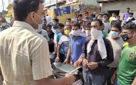 假酒中毒事件發生後，村民與一名官員交談。（圖源：PTI）