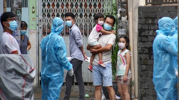 醫護人員給家住舊邑郡阮文功街415小巷的居民採樣檢測。