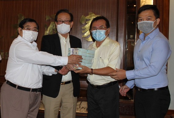 萬盛發集團代表張豐裕（左二）向二府會館理事會和建築公司代表移交最後一期捐款。