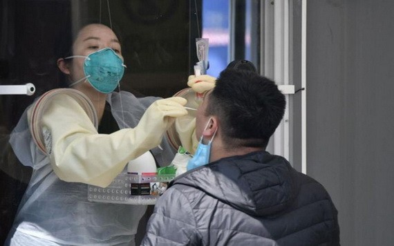 在檢測室內不用穿防護服的醫護人員為民眾採樣檢測。