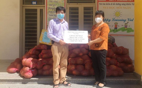 華人企業家陳偉民（左）接收大勒花卉協會的蔬菜以運抵本市。