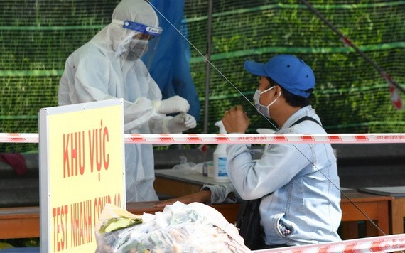 茶榮省防疫工作人員在一個檢疫點為一名過站男性進行快捷核酸檢測。(圖源:胡江)