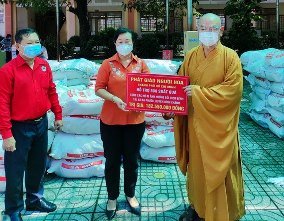 釋慧功法師向張瑞玲主席轉交救濟物資。