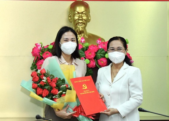 范氏清賢同志(左)從市人民議會主席阮氏麗手中接過委任《決定》和祝賀鮮花。(圖源:越勇)