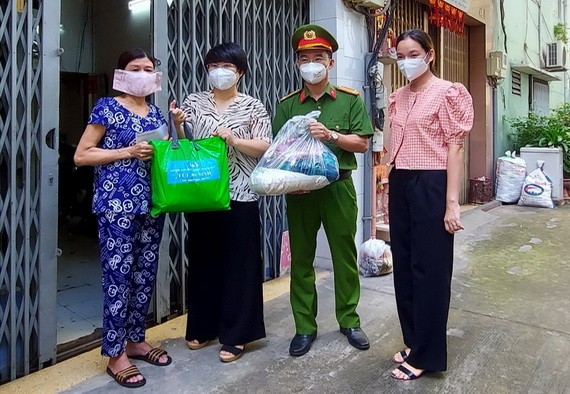 第五郡人委會主席張明嬌(左二)與各代表送援助品給民戶。