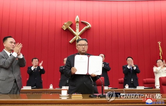 圖為朝鮮勞動黨總書記金正恩出示親自署名的文件。 (圖源:韓聯社/朝中社)